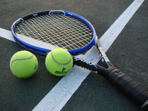 pair of tennis rackets with balls